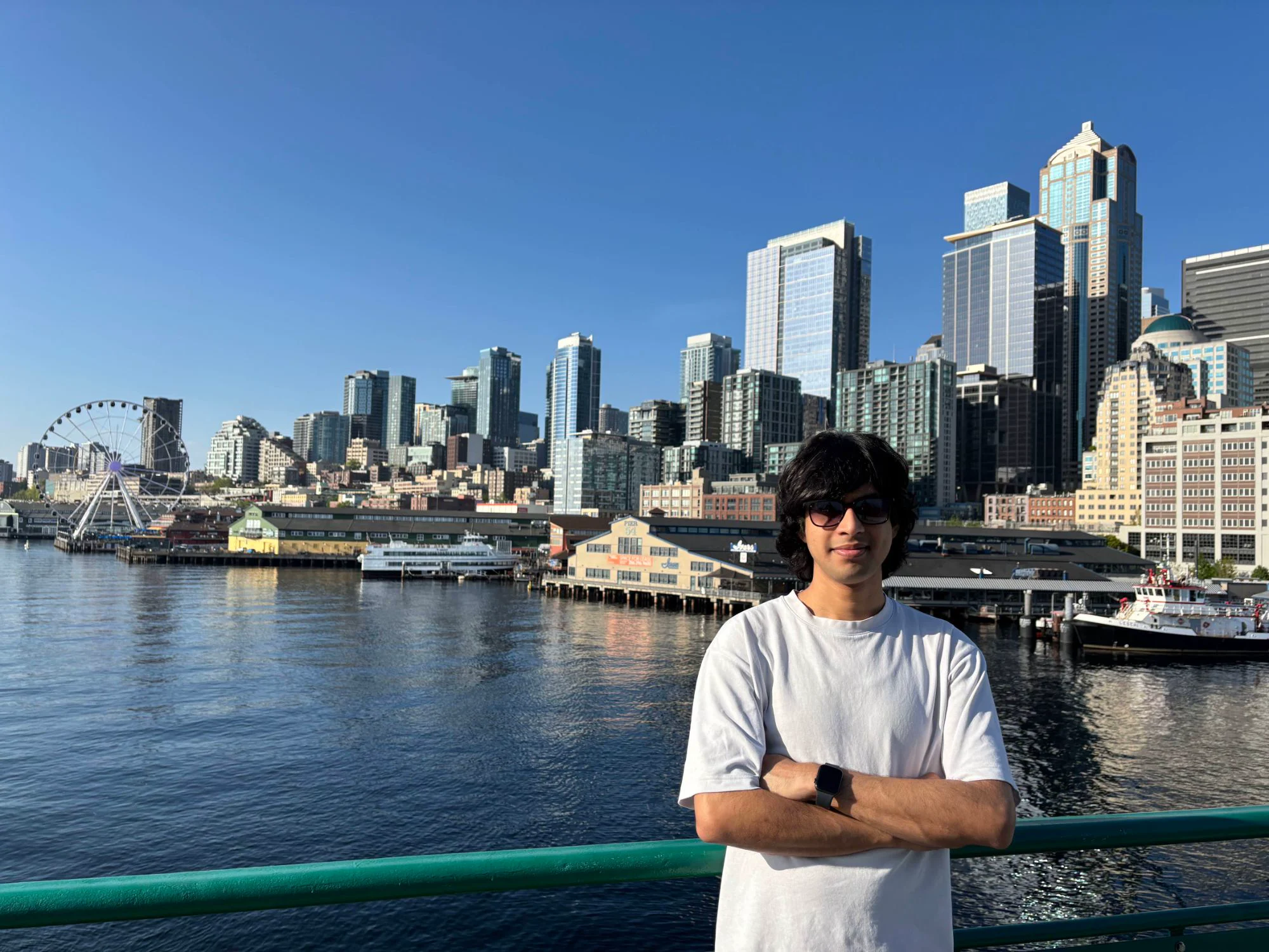 Saksham on the Seattle waterfront with the downtown skyline behind him